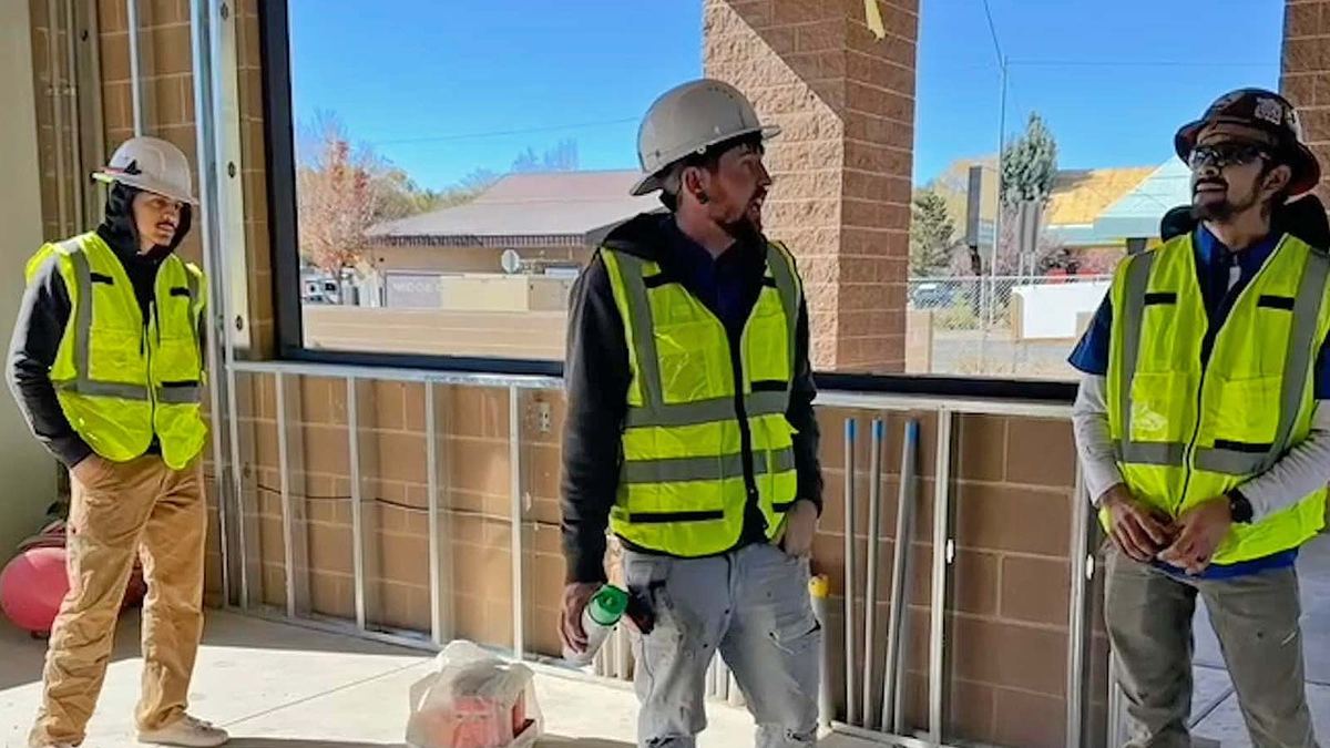Three Nichols crew members in safety vests on a commercial job site