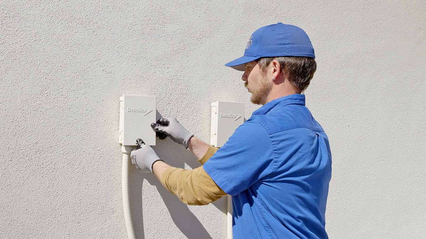 Nichols electrician working on an exterior electrical panel